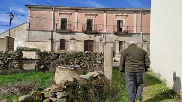 El alcalde de Benquerencia, Alberto Buj, de espaldas ante un edificio del pueblo.