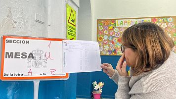 Una mujer busca su Mesa electoral en el CEIP Trajano de M�rida