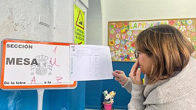 Una mujer busca su Mesa electoral en el CEIP Trajano de M�rida