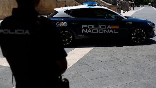 Imagen de archivo de un agente y un coche patrulla de la Polic�a Nacional.