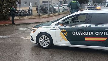 Dos agentes de la Guard�a Civil junto a un veh�culo