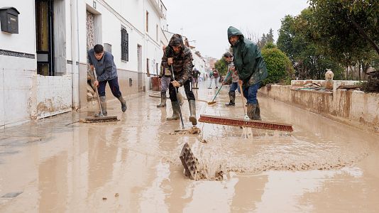 Vecinos Villanueva Mes�a, Granada se afanan por sacar agua y barro de las calles tras la crecida del r�o Genil.