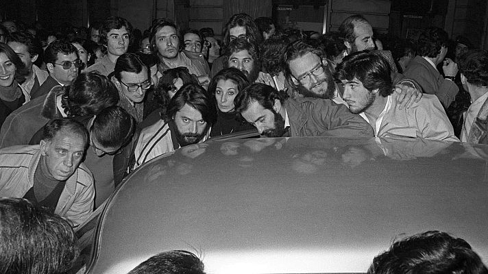 Un grupo de periodistas en torno a un coche que tiene la radio puesta la noche del 23 F