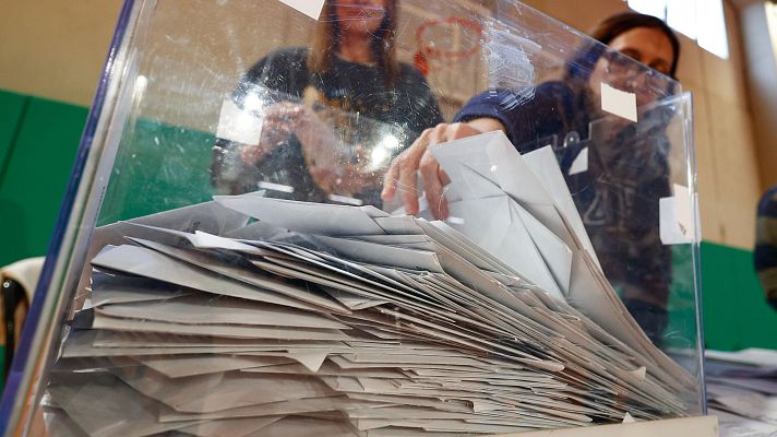Los miembros de una mesa electoral proceden a la apertura de las urnas para el recuento de votos
