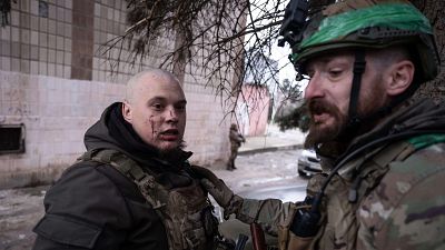 Un soldado calma a un compa�ero de armas que ha sufrido una herida en la cara en la ciudad de primera l�nea de Druzhkivka, en la regi�n de Donetsk, Ucrania.