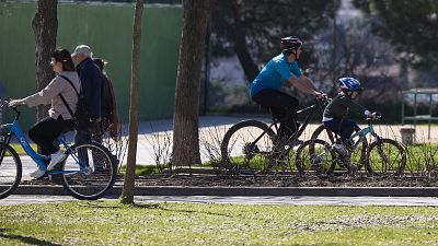 Varias personas disfrutan del buen tiempo en el parque Juan Carlos I de Madrid.