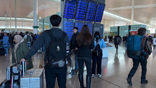 Usuaris consultant un panell informatiu a l?aeroport del Prat
