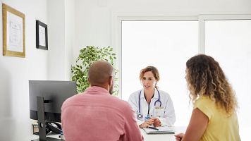 Una m�dica atiende a dos pacientes.