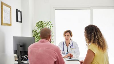 Una m�dica atiende a dos pacientes.