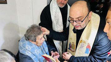 El sacerdote Gabriel Romanelli bendiciendo a una mujer cristiana de Gaza
