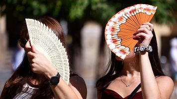 Turistas se protegen con abanicos para aliviar las altas temperaturas en C�rdoba.