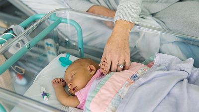 Un beb� reci�n nacido agarra con sus deditos la mano de su madre