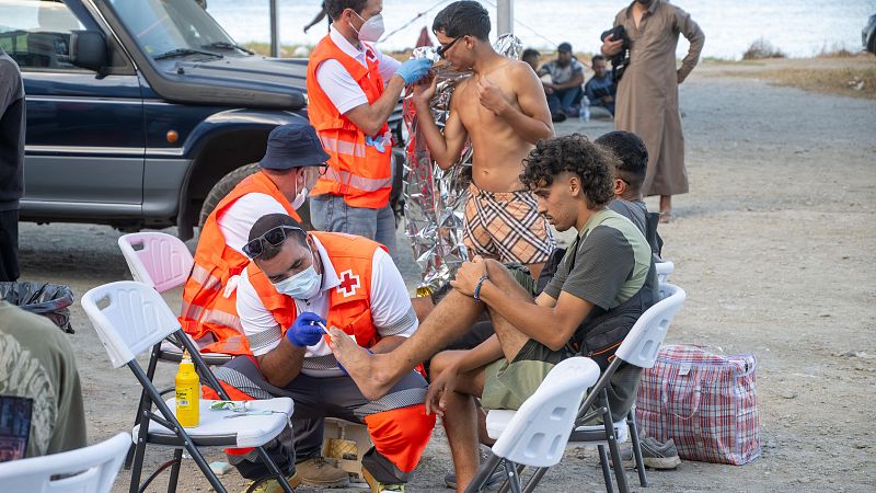 Miembros de la Cruz Roja atienden a varios inmigrantes, en la playa del Trampol�n