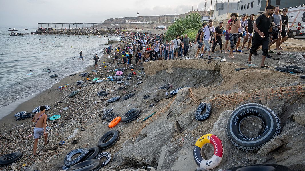 Decenas de migrantes celebran haber traspasado la frontera entre Ceuta y Marruecos, a 31 de julio de 2026