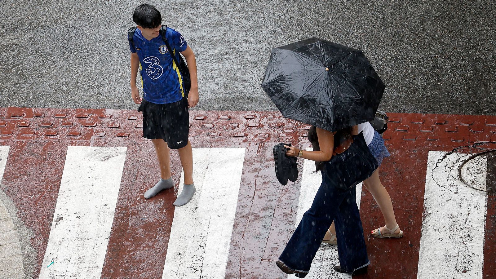 Varias personas en una calle del centro de Barcelona bajo la tormenta
