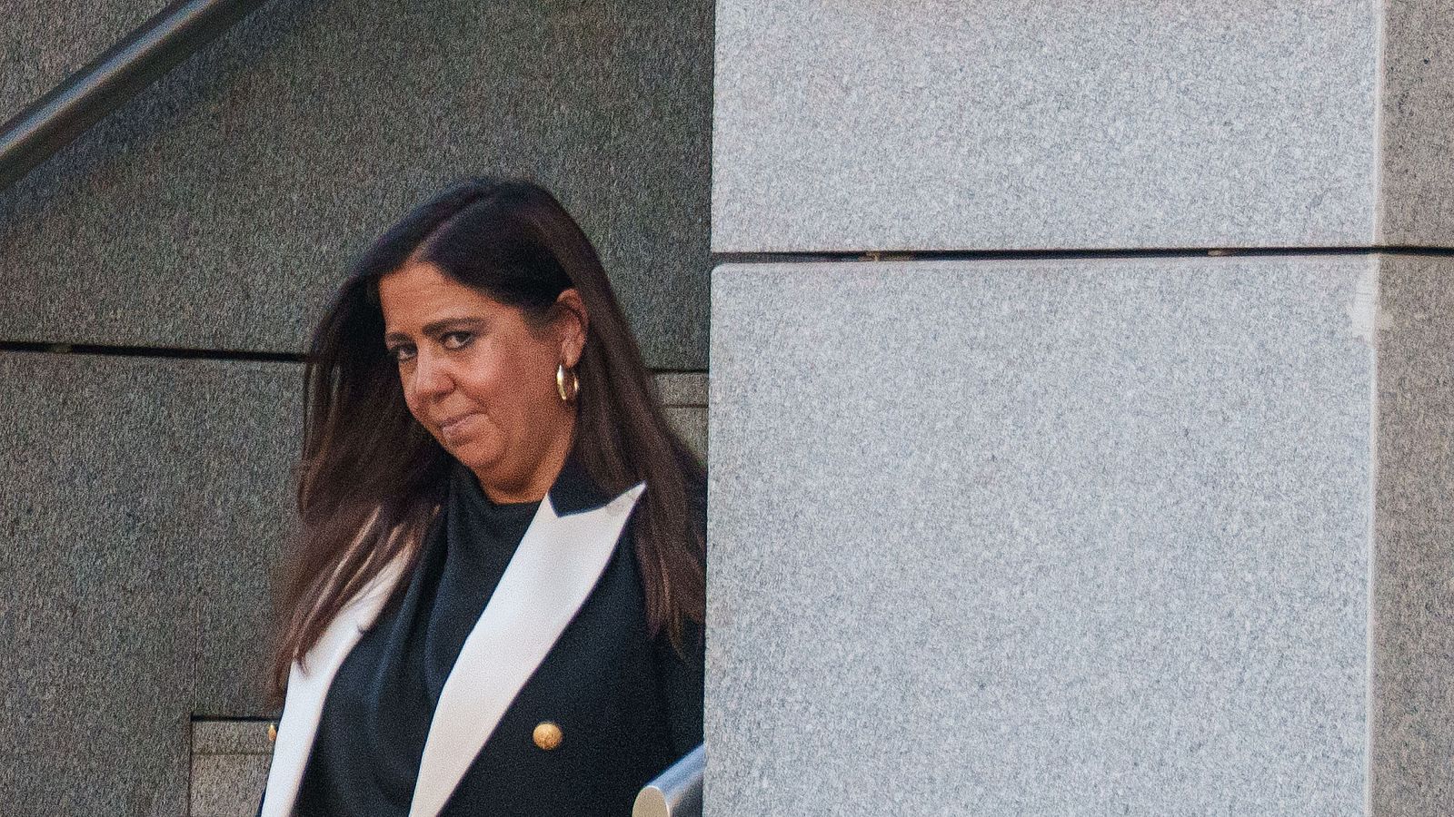 La jueza Beatriz Biedma con expresión seria, cabello castaño y chaqueta oscura de solapas blancas junto a un pilar de piedra.