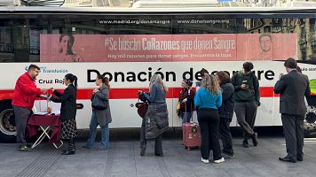 Varias personas donan sangre en un autob�s de la Cruz Roja situado en la Gran V�a de Madrid
