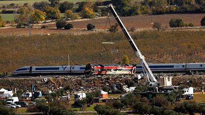 Una gr�a eleva un vag�n de tren tras el accidente en Urda