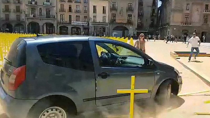 Un coche arrolla cruces amarillas por los presos en la plaza de Vic