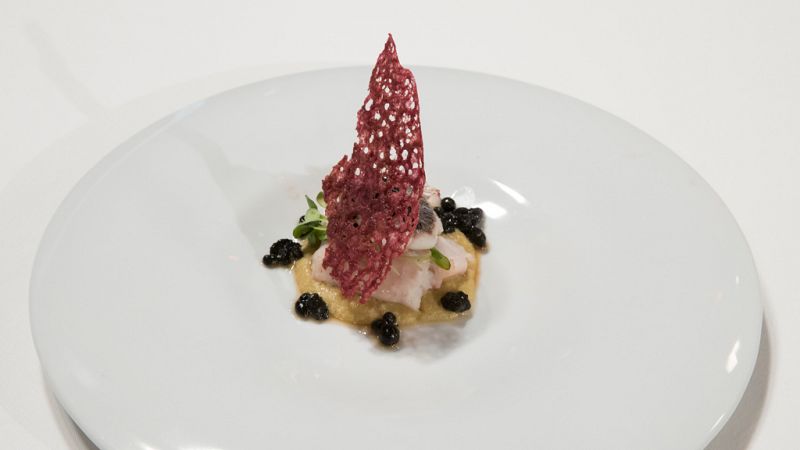 Merluza cocinada al vacío, con falso caviar de ajo negro, emulsión de aceituna verde y coral de Josetxo
