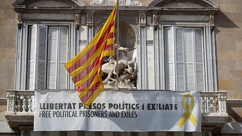 Un grupo de encapuchados trata durante la madrugada de retirar los lazos amarillos de la Generalitat