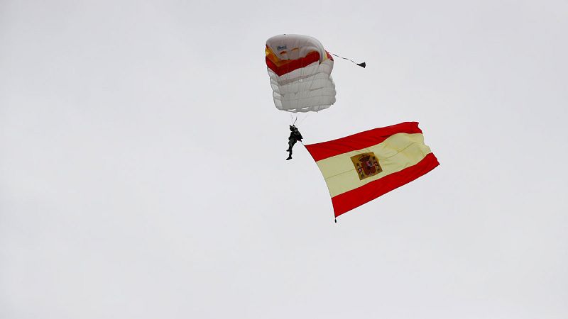 El paracaidista que descendía con la bandera de España impacta contra una farola y queda enredado