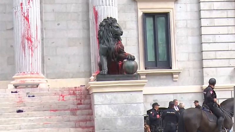 Activistas por el clima tiran pintura roja biodegradable a la fachada de los Leones del Congreso
