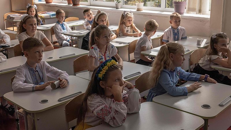 Los niños inician su primer día de clase en Ucrania con flores y canciones patrióticas mientras la guerra continúa