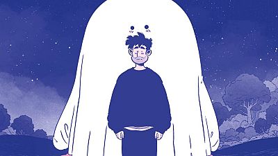 En la portada de un cómic, un hombre con barba y ropa oscura se encuentra frente a una figura fantasmal blanca con ojos negros, sobre un fondo de cielo nocturno con estrellas y vegetación azulada. En la portada de un cómic, un hombre con barba y ropa oscura se encuentra frente a una figura fantasmal blanca con ojos negros, sobre un fondo de cielo nocturno con estrellas y vegetación azulada.