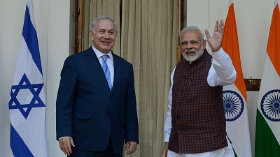 Benjamin Netanyahu y Narendra Modi, líderes de Israel e India, sonríen en un encuentro diplomático con las banderas nacionales de fondo. Benjamin Netanyahu y Narendra Modi, líderes de Israel e India, sonríen en un encuentro diplomático con las banderas nacionales de fondo.