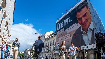 Los bomberos retiran la lona de Hazte Oír contra Pedro Sánchez desplegada frente al Congreso