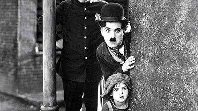 Charlie Chaplin, conocido como Charlot, se esconde tras un muro junto a un niño en una escena de la película 'The Kid'. Charlie Chaplin, conocido como Charlot, se esconde tras un muro junto a un niño en una escena de la película 'The Kid'.