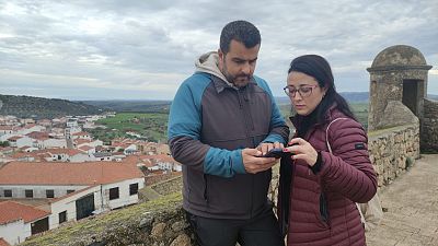 Isaac y Rosa, vecinos de Valencia de Alcántara, consultan su teléfono para comprobar la conexión a internet.