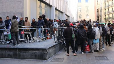 La cua de migrants per fer tràmits per la regularització dona diverses voltes al darrere de l'Ajuntament de Barcelona