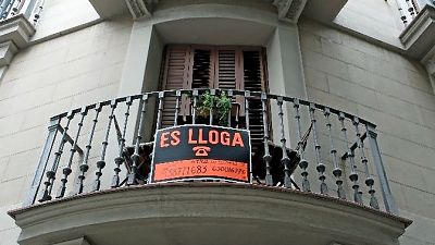 Cartel naranja y negro en balcón: "ES LLOGA", "ATICO EN TERRASSA", teléfonos 638771683 y 630016776. Balcón semicircular con barandilla de hierro forjado. Cartel naranja y negro en balcón: "ES LLOGA", "ATICO EN TERRASSA", teléfonos 638771683 y 630016776. Balcón semicircular con barandilla de hierro forjado.