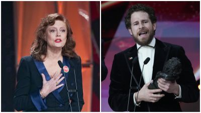 En la imagen, Susan Sarandon y Álvaro Cervantes celebran sus premios. Ella viste un traje oscuro con un pin, mientras que él lleva un esmoquin negro, ambos frente a micrófonos.