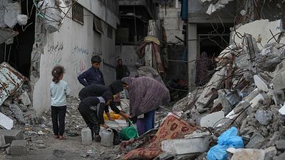 Palestinos recogen agua de una manguera durante una tormenta en el barrio de Sheikh Radwan, en la ciudad de Gaza Palestinos recogen agua de una manguera durante una tormenta en el barrio de Sheikh Radwan, en la ciudad de Gaza