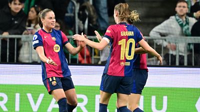 Celebración de dos jugadoras del Barça tras un gol; una de ellas, Caroline Graham Hansen (dorsal 10), muestra alegría y estrecha la mano de su compañera.