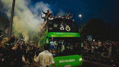 Celebración del ascenso del Real Racing Club a Primera División con su autobús verde, jugadores eufóricos y aficionados vitoreando en las calles de Cantabria. Celebración del ascenso del Real Racing Club a Primera División con su autobús verde, jugadores eufóricos y aficionados vitoreando en las calles de Cantabria.