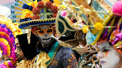 Diversidad de trajes y tocados coloridos en un evento turístico. Una persona lleva maquillaje de calavera y sombrero decorado. Amplia representación cultural. Diversidad de trajes y tocados coloridos en un evento turístico. Una persona lleva maquillaje de calavera y sombrero decorado. Amplia representación cultural.