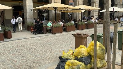 Persones dinant a la plaça Independència de Girona i brossa acumulada Persones dinant a la plaça Independència de Girona i brossa acumulada