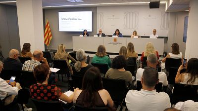 Evento institucional sobre el calor en el trabajo en Lleida, con ponentes y audiencia en una sala de conferencias. Se visualiza un protocolo de actuación en una pantalla. Evento institucional sobre el calor en el trabajo en Lleida, con ponentes y audiencia en una sala de conferencias. Se visualiza un protocolo de actuación en una pantalla.