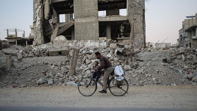 Un hombre sirio pasea en bicicleta entre edificios destruidos en Harasta. Un hombre sirio pasea en bicicleta entre edificios destruidos en Harasta.