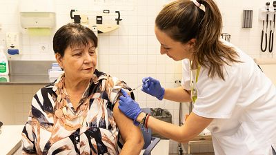 Una professional sanitària adminstra una vacuna contra la grip a una dona en el CAP Rieral de Lloret de Mar | ACN