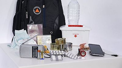 Mochila de emergencia con llaves y móvil lista junto a la puerta de una casa ante el riesgo de incendio forestal.