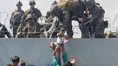 La imagen de la desesperación: un bebé es entregado por encima de un muro en Kabul a soldados de EE.UU.