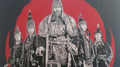 Portada de cómic: cinco figuras en atuendos tradicionales mongoles sobre fondo rojo circular y negro. El personaje central destaca por su tamaño y tocado. Portada de cómic: cinco figuras en atuendos tradicionales mongoles sobre fondo rojo circular y negro. El personaje central destaca por su tamaño y tocado.