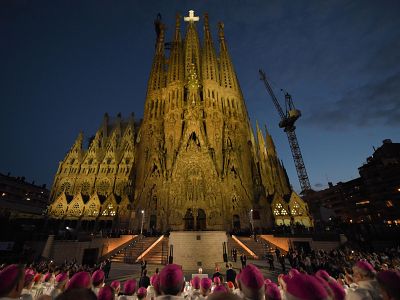 El Papa Lleó XIV, vestido con ornamentos papales blancos, bendice la Torre de Jesús de la Sagrada Familia, rodeado de obispos y cardenales, ante una multitud congregada. El Papa Lleó XIV, vestido con ornamentos papales blancos, bendice la Torre de Jesús de la Sagrada Familia, rodeado de obispos y cardenales, ante una multitud congregada.