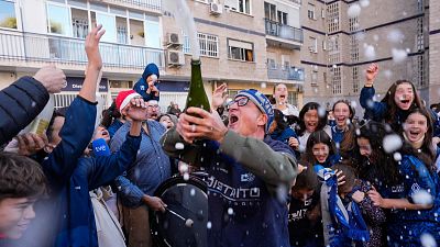 Un grupo de personas celebran en el club de baloncesto Distrito Olímpico de Madrid el Gordo de la Lotería de Navidad 2024