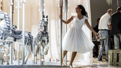 Manon Lescaut con un vestido blanco gira en un carrusel Manon Lescaut con un vestido blanco gira en un carrusel